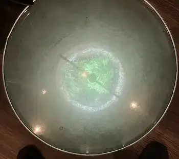 A top-down shot of a covered, backlit well in a Lancaster pub floor, apparently Roman
